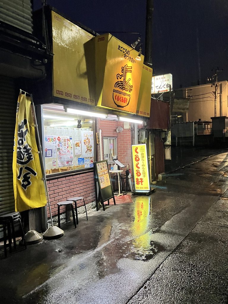 福島県の中華料理店くるくる軒の夜の外観。黄色い看板と店先の様子